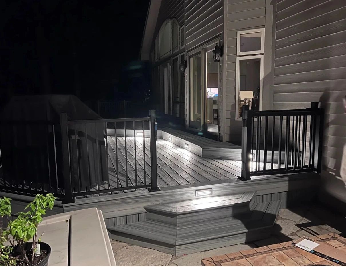 Modern residential deck at night with black railings