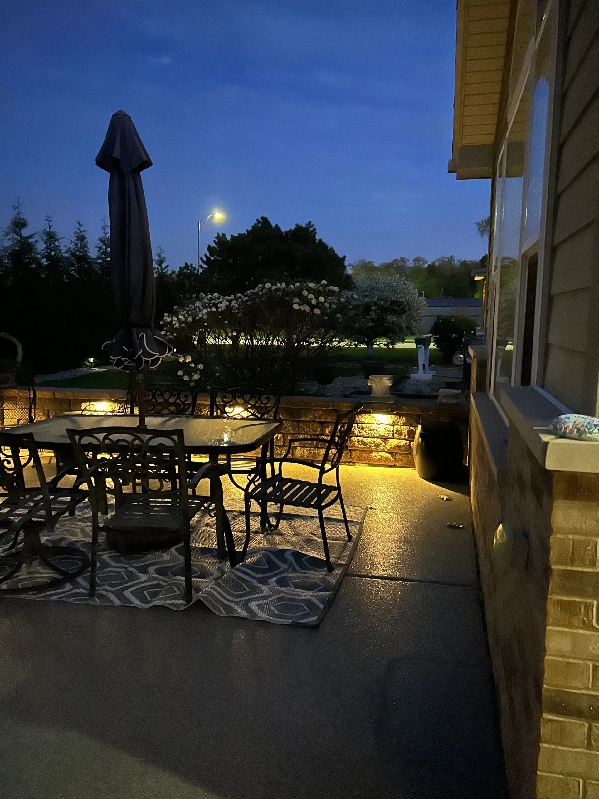 Elegant patio outdoor dining area with accent lighting at evening