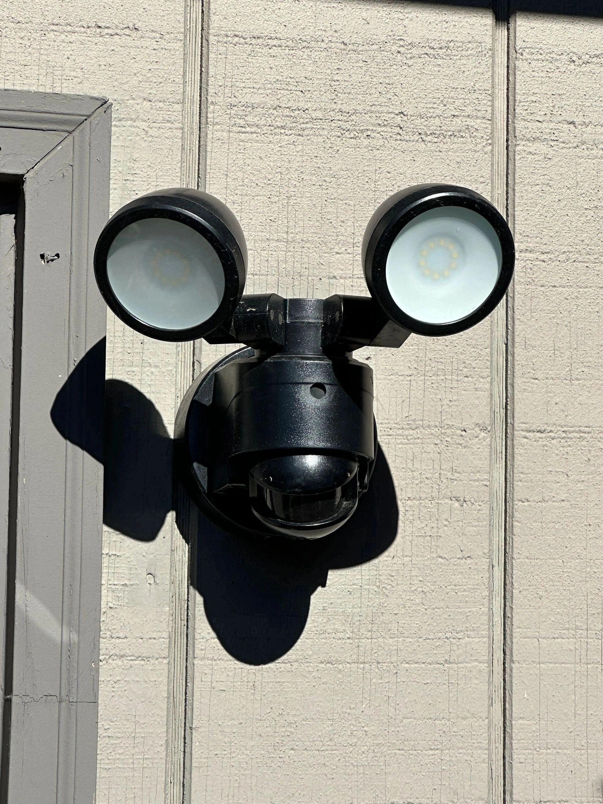 Dual-head motion sensor security light on wall